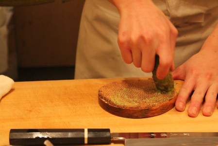 Fresh wasabi being grated on dried sharkskin.